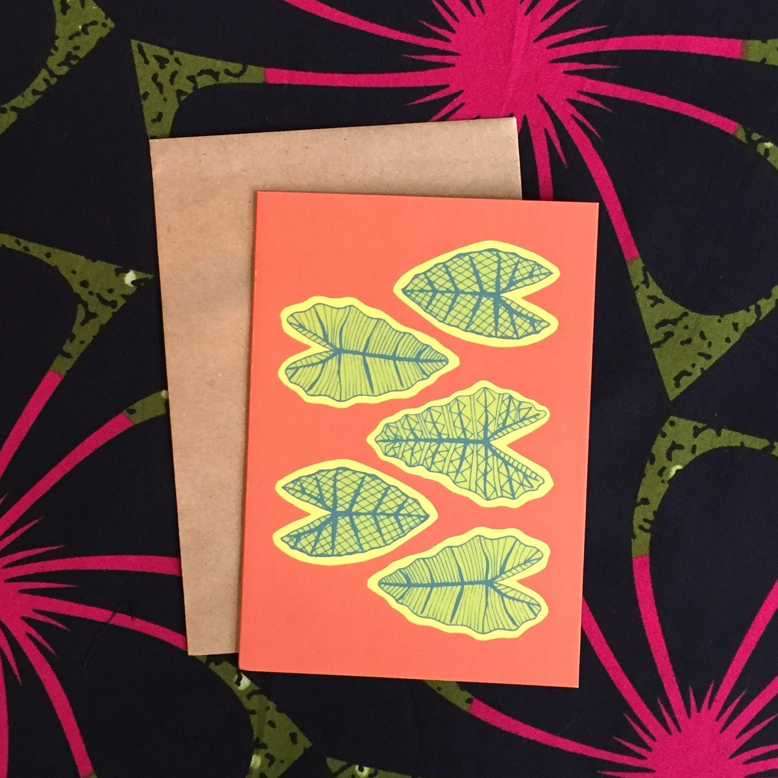 Red greeting card with yellow and green tropical leaves