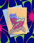 Paster orange greeting card with 2 lavender, yellow red and orange owls