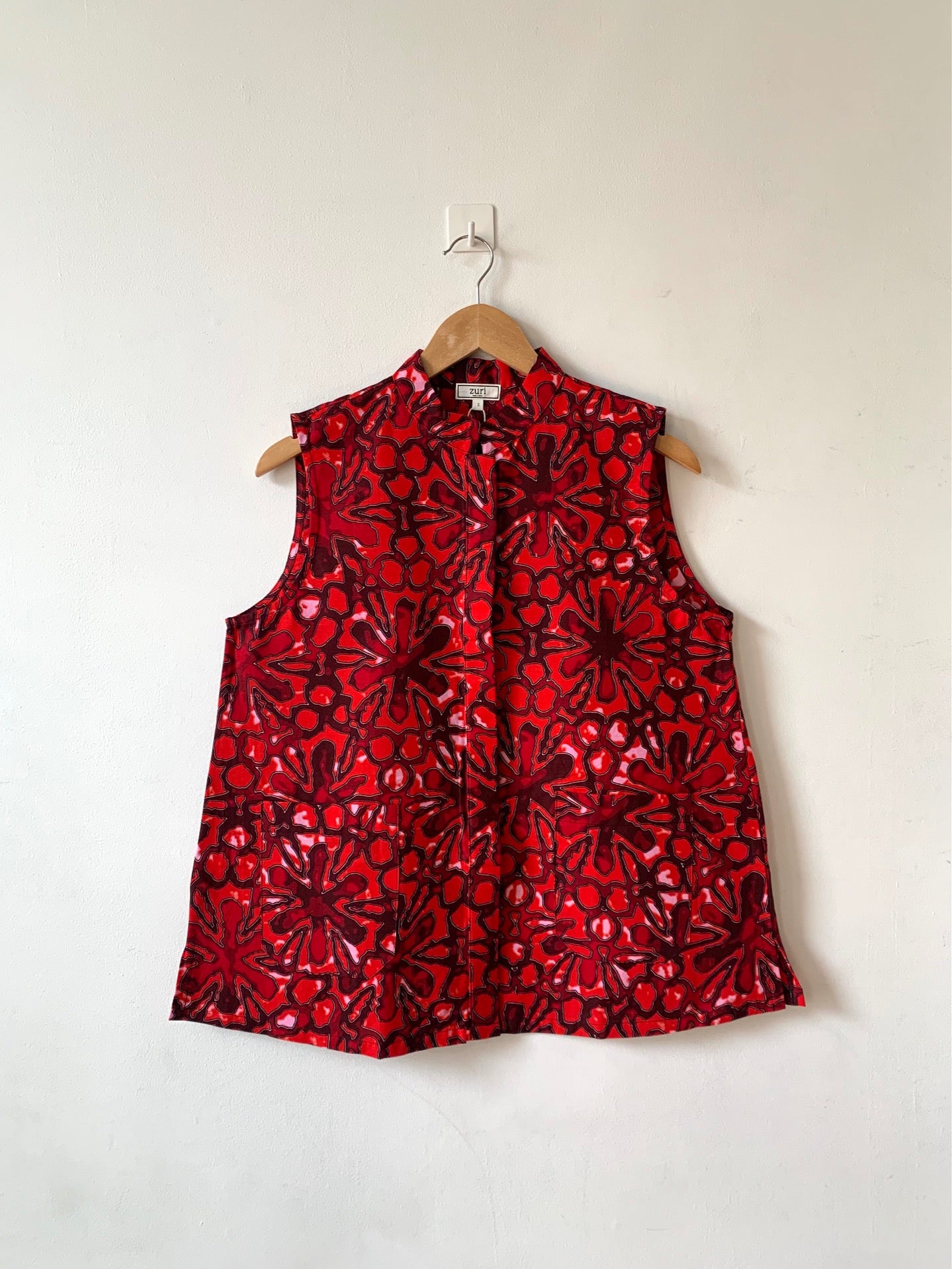 Display of red floral print sleeveless shirt.