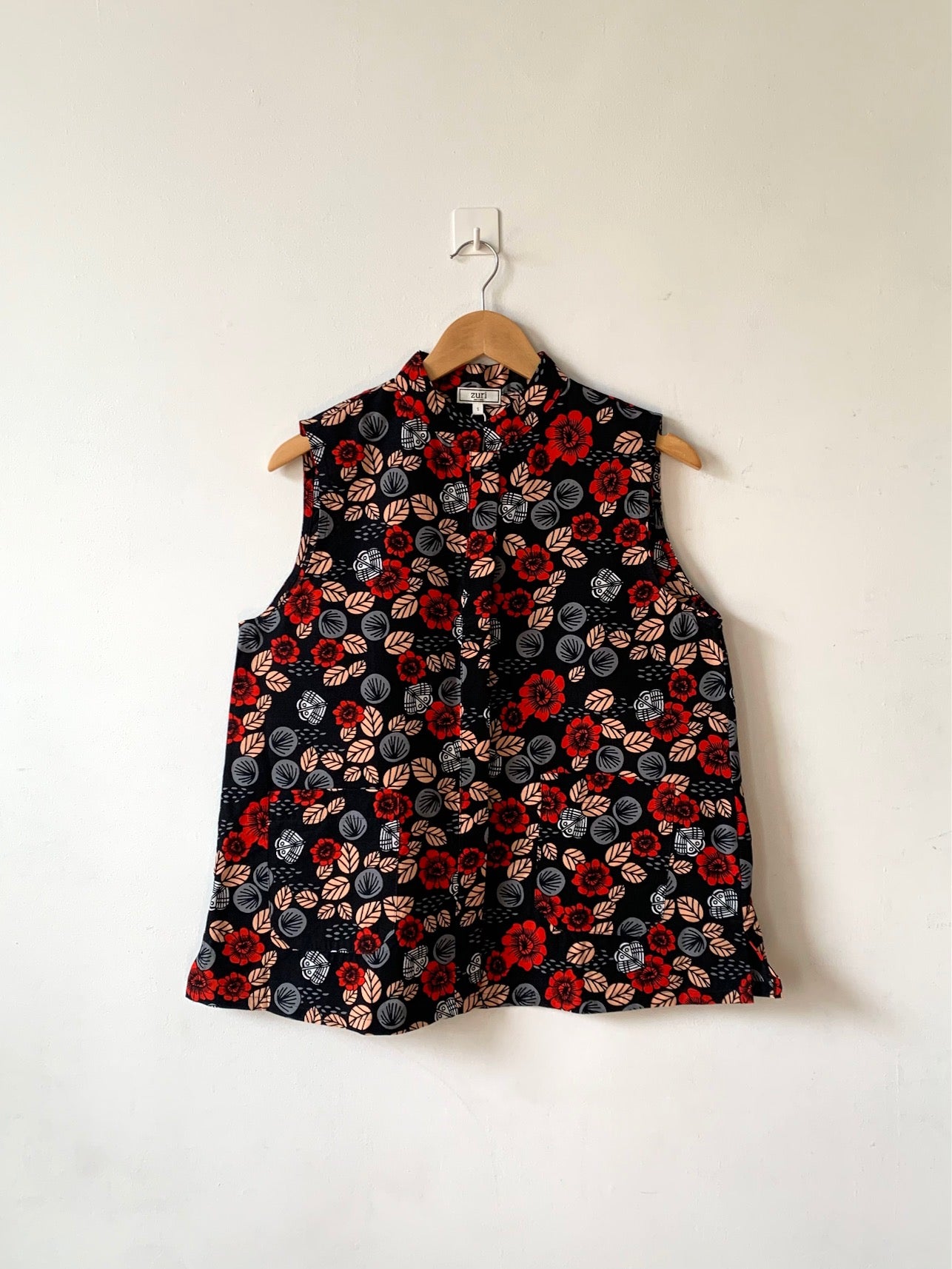 Display of black sleeveless shirt with red, grey and beige floral print