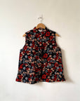 Display of black sleeveless shirt with red, grey and beige floral print