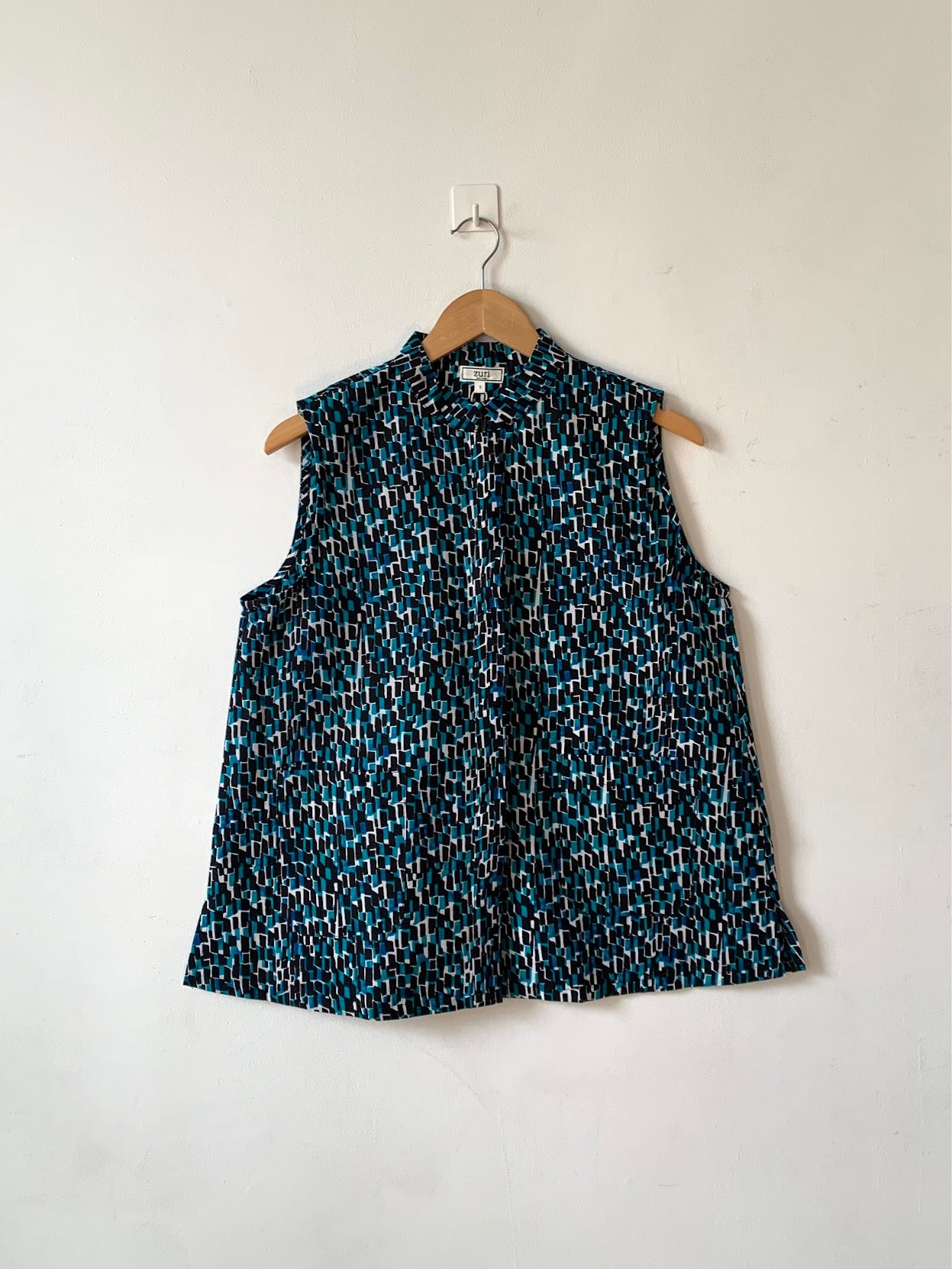 Display of blue, black and white abstract print sleeveless shirt. 