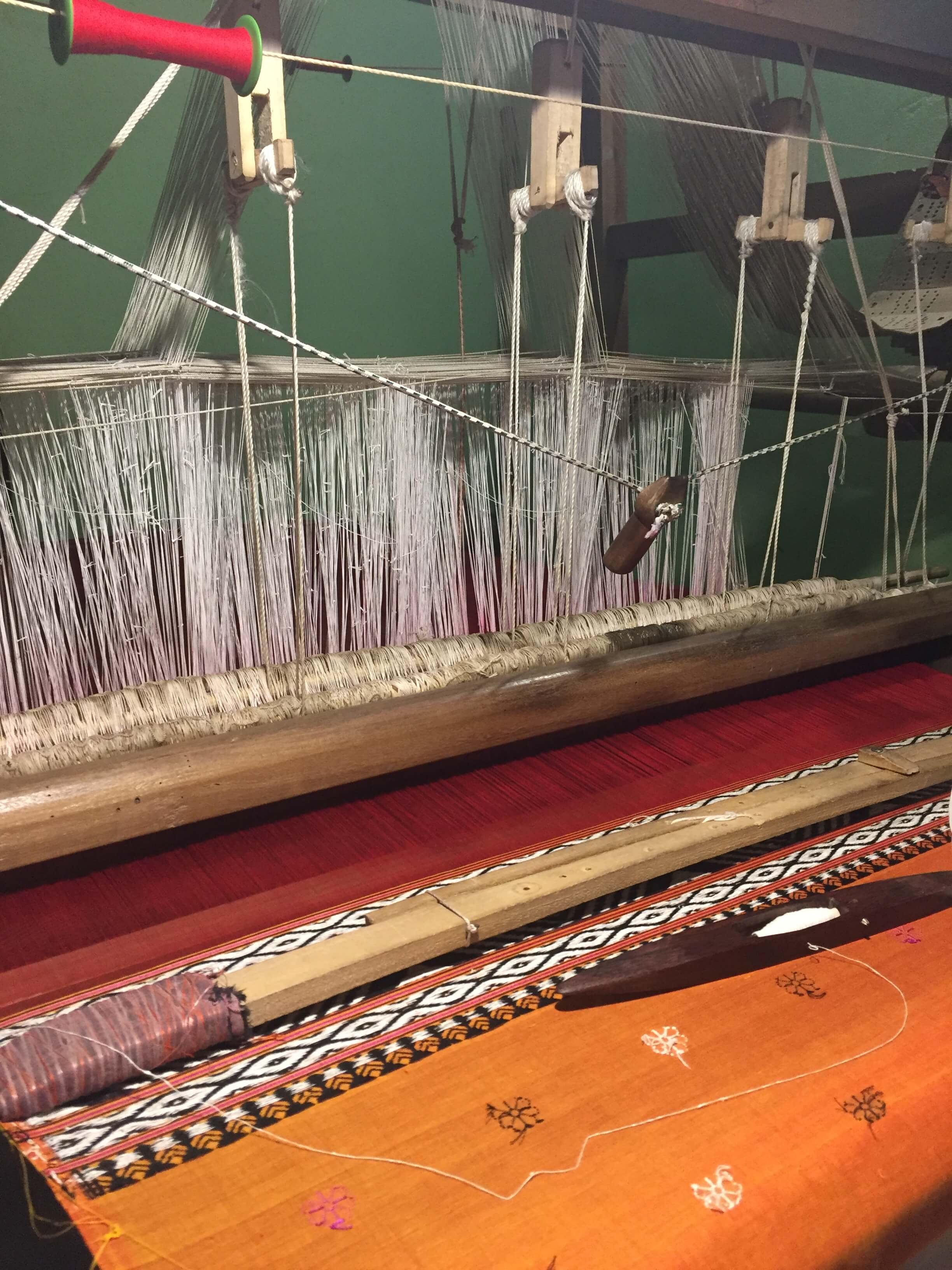 Image of a loom with woven fabric