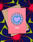 Coral color greeting card with purple and blue heart.