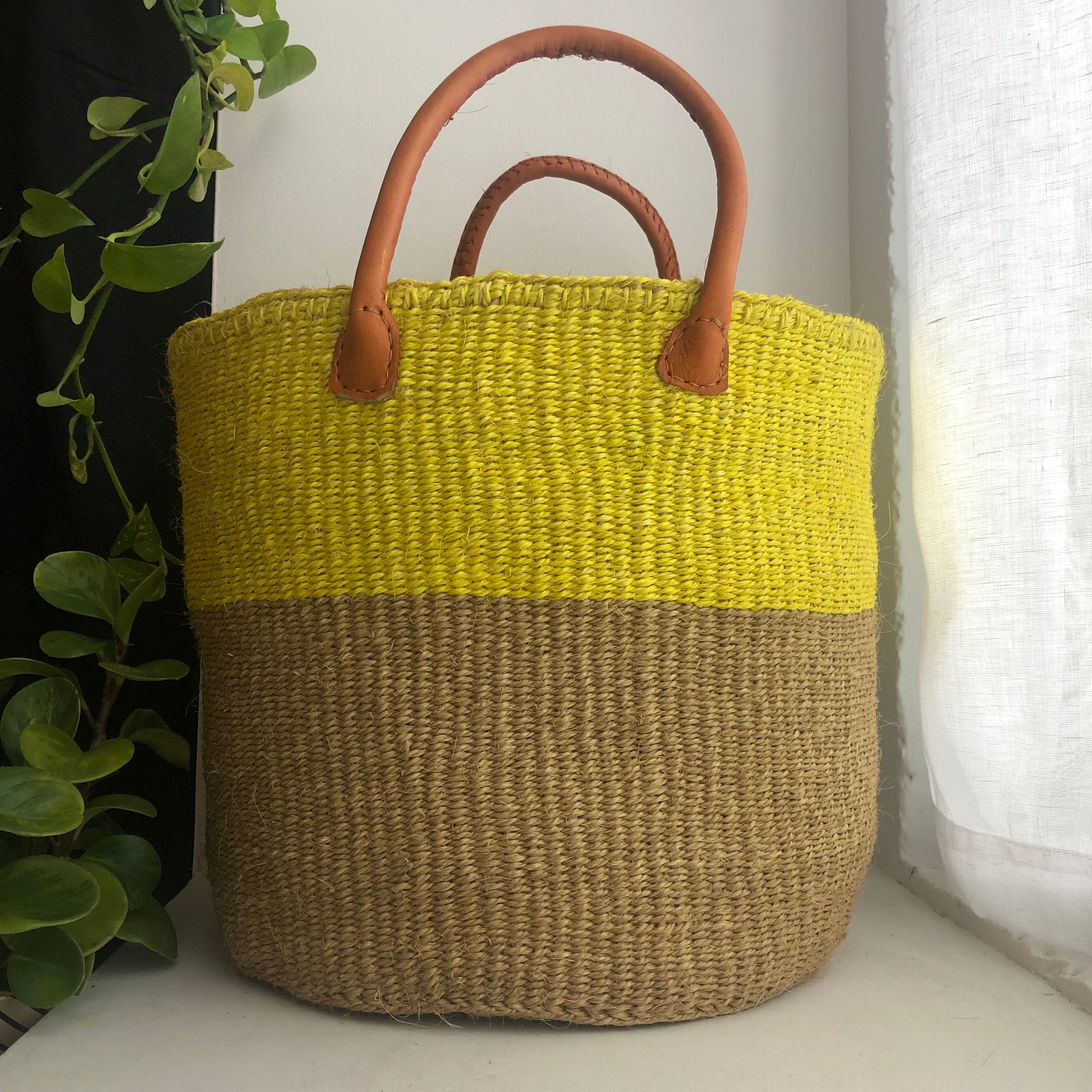 Yellow basket with leather handles.