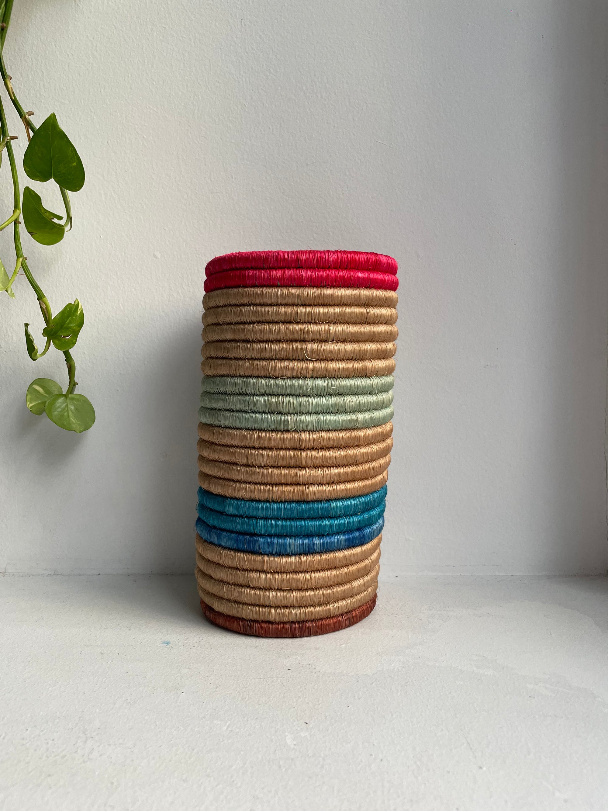 Display of hot pink, beige, blue and sage green striped vase