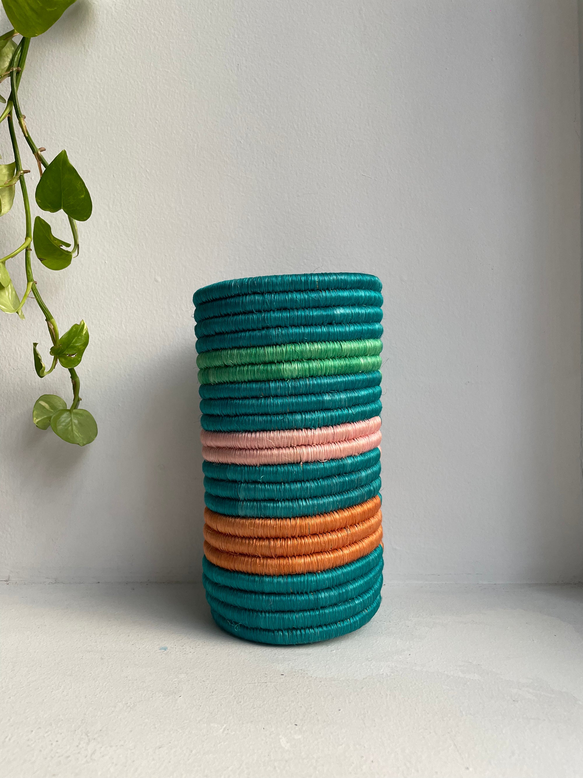 Display of bubble gum, orange and aqua striped vase