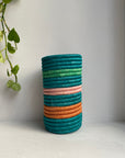 Display of bubble gum, orange and aqua striped vase