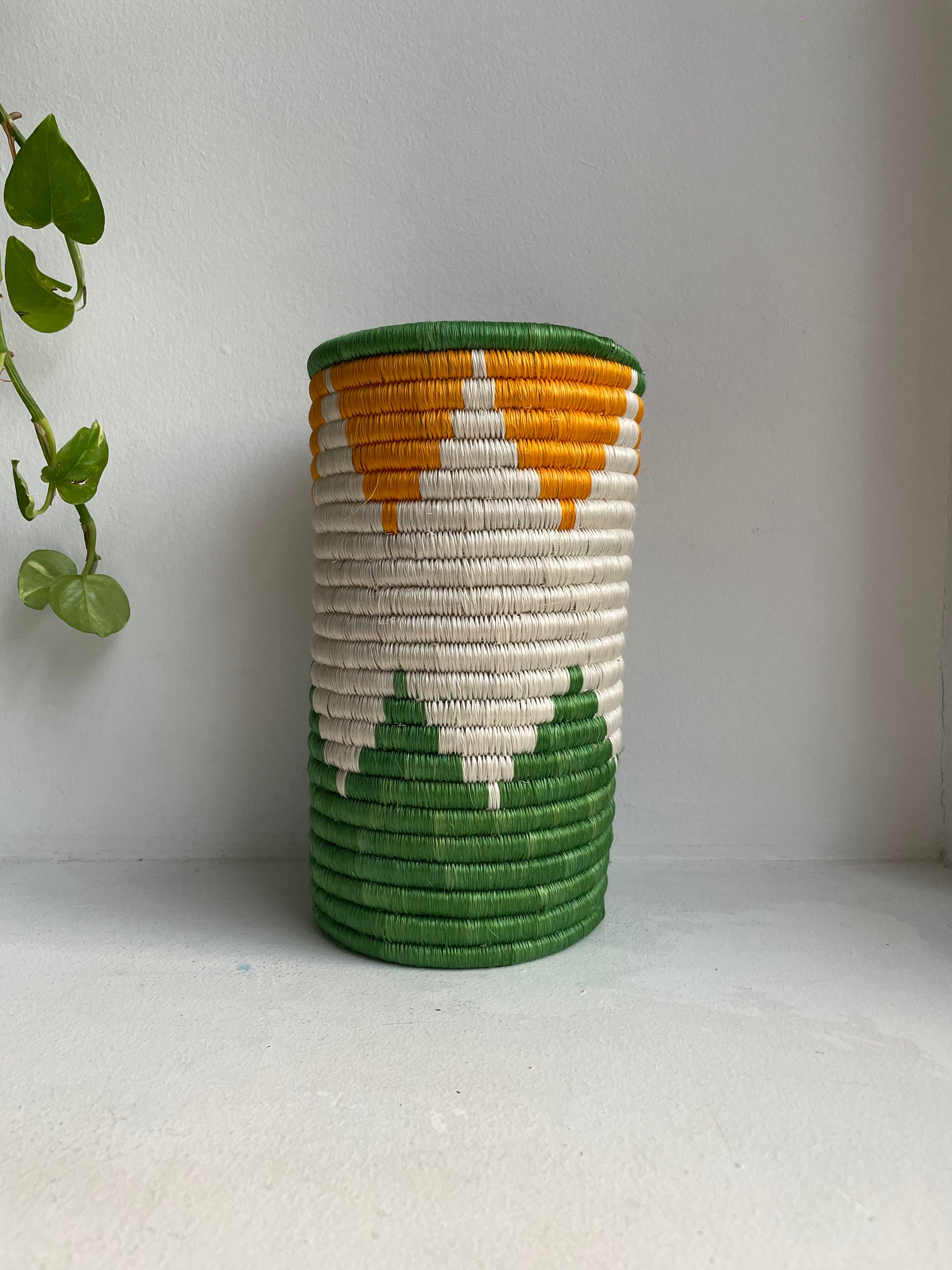 Display of orange, green and white geometric colored vase