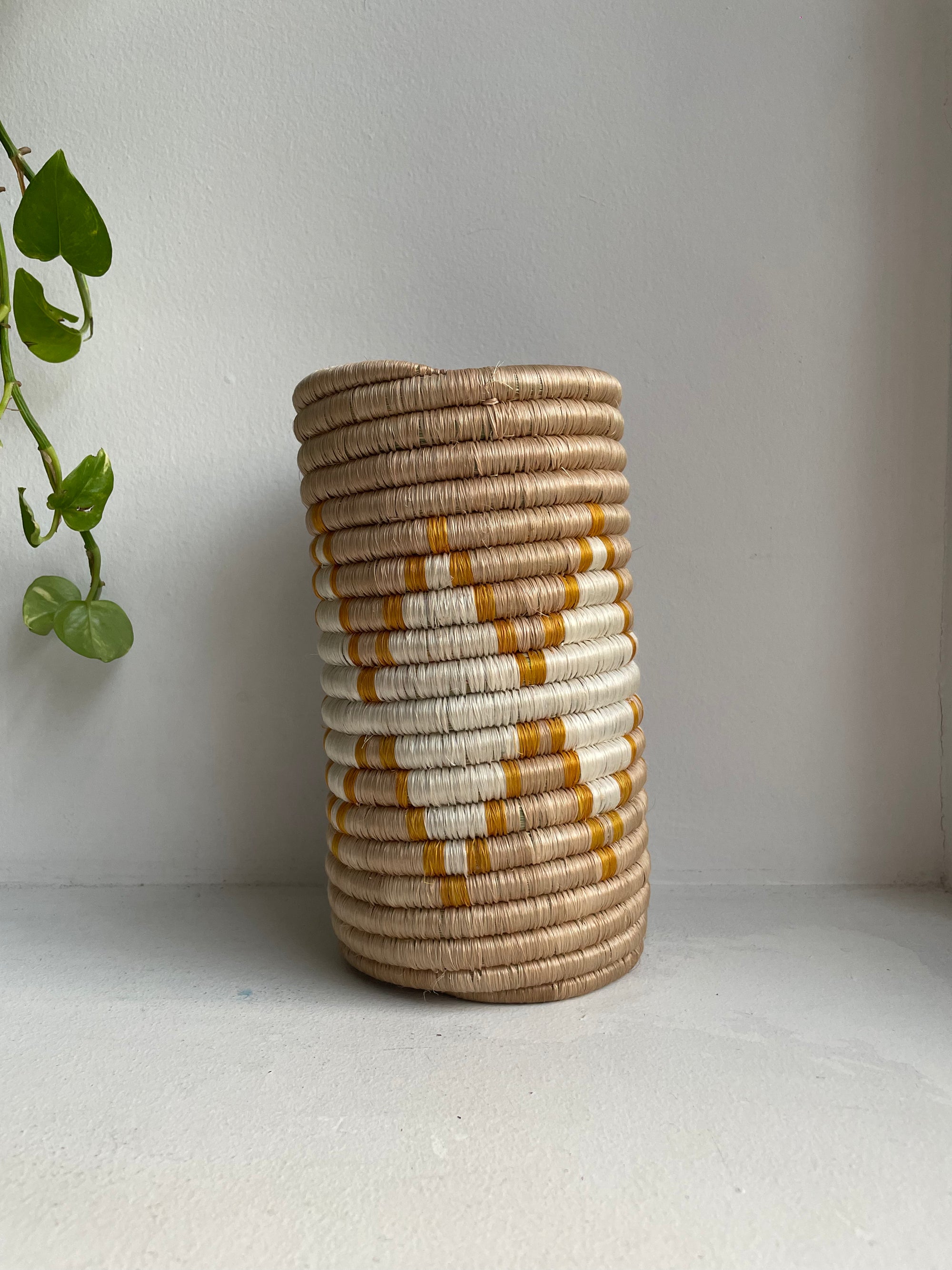 Display of beige, white and yellow colored vase