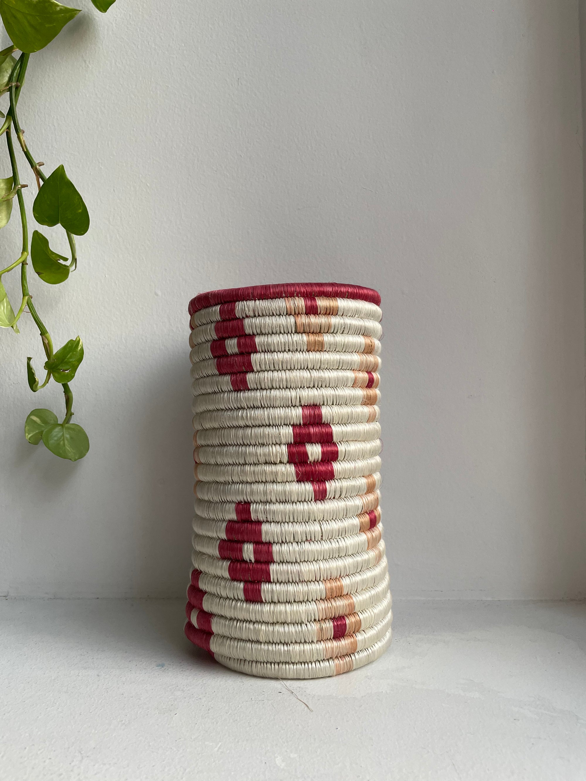 Display of white vase with burgundy flowers