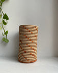 Display of beige and orange colored vase
