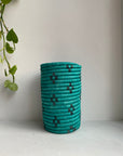Display of mint blue colored vase with black flowers
