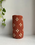 Display of bright brown colored vase with beige flowers