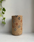 Display of beige colored vase multicolored floral design