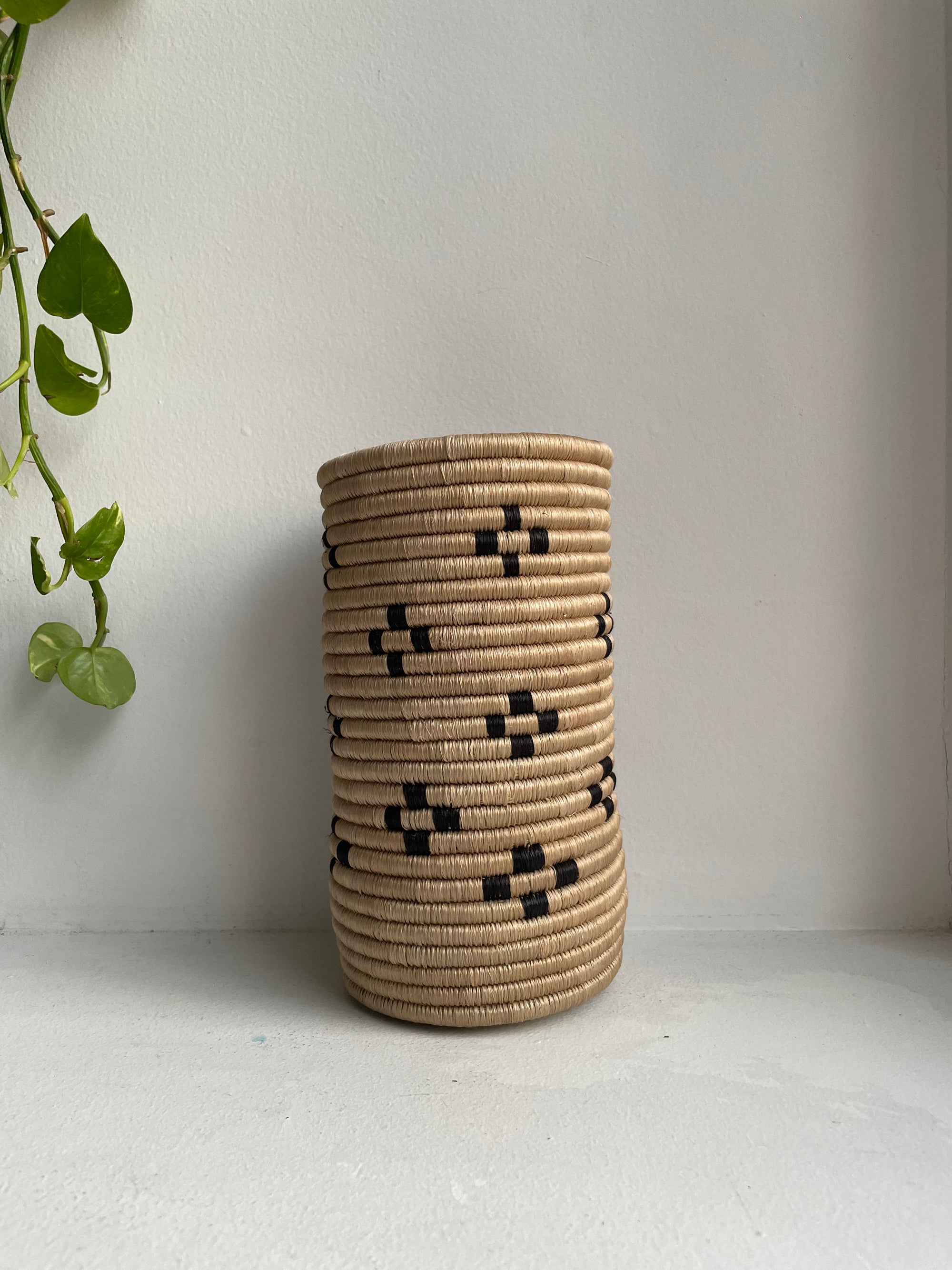 Display of beige and black colored vase with floral design