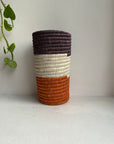 Display of orange, white and dark brown colored vase