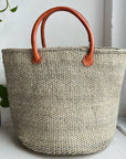 taupe woven sisal basket with leather handle.