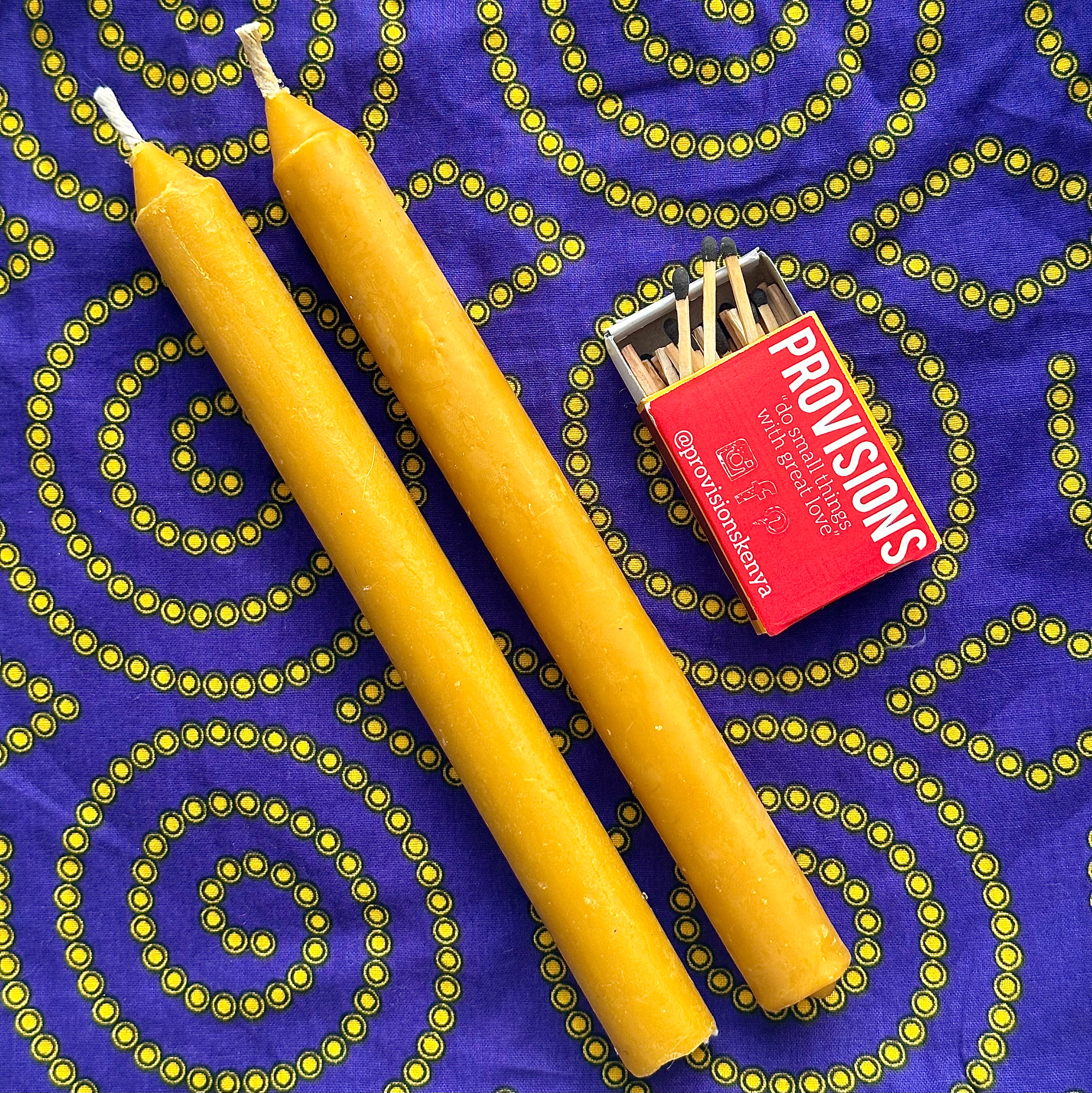 display of 2 taper beeswax candles and matches