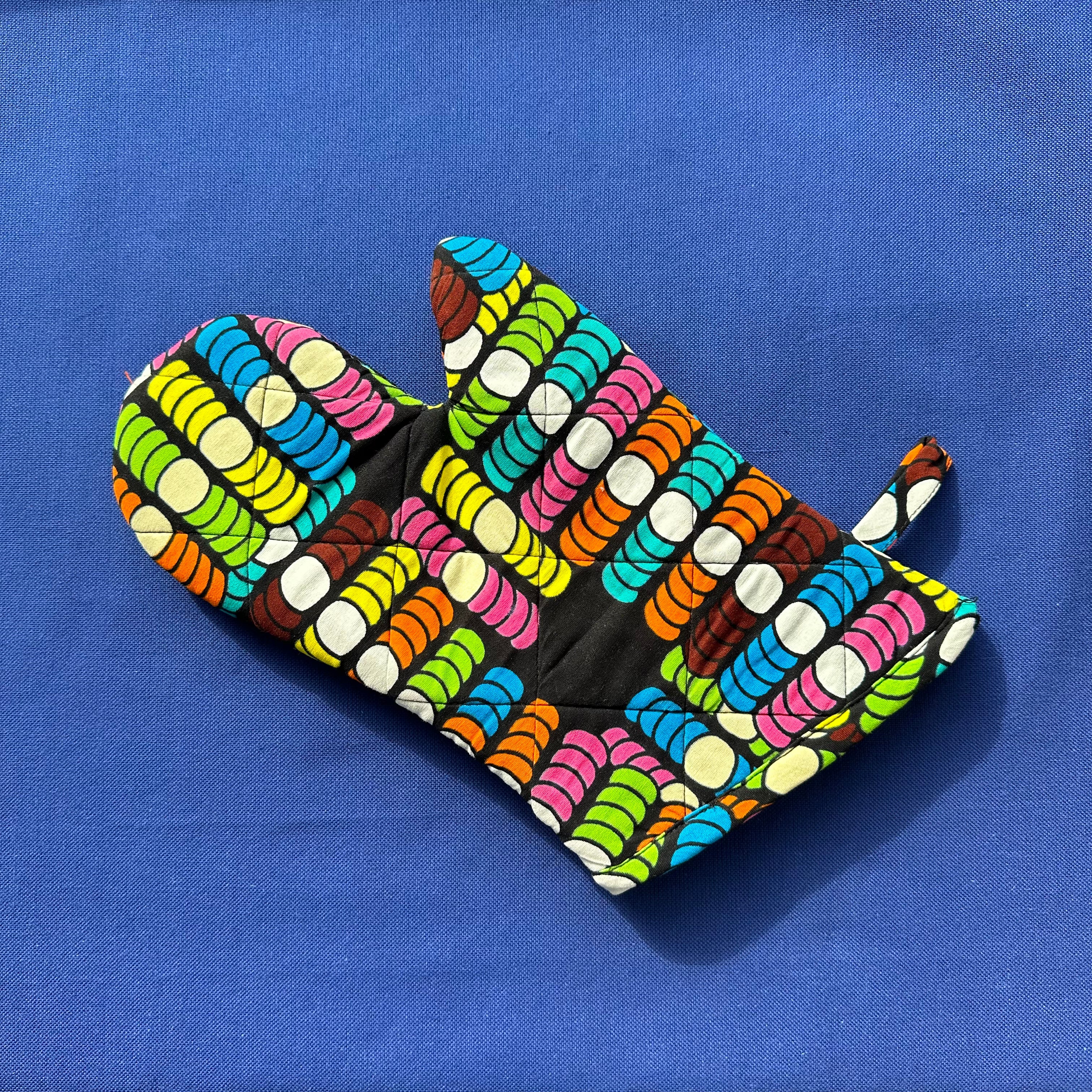 Display of rainbow dotted oven mitt
