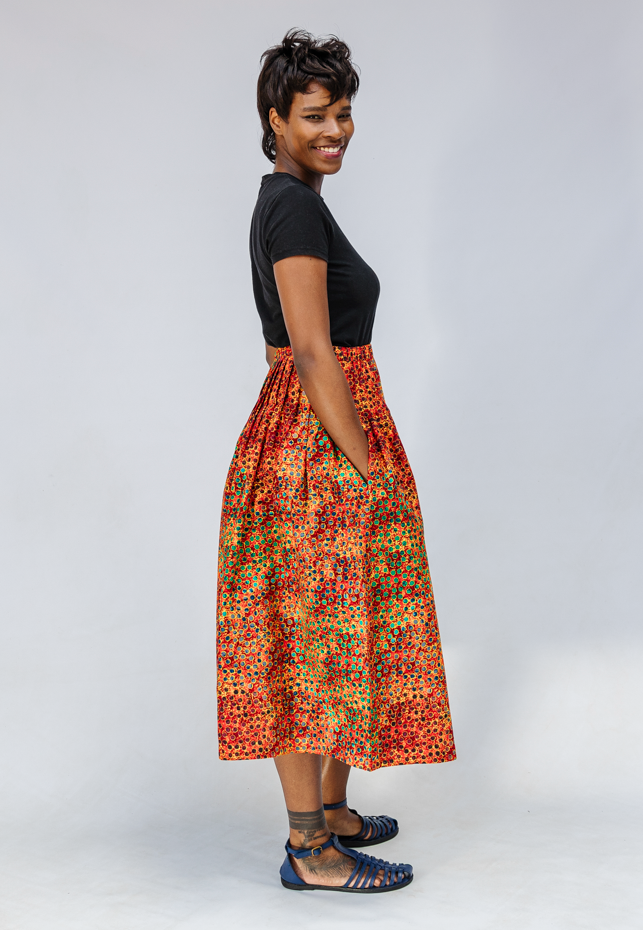 Model wearing multicolored dot print skirt.