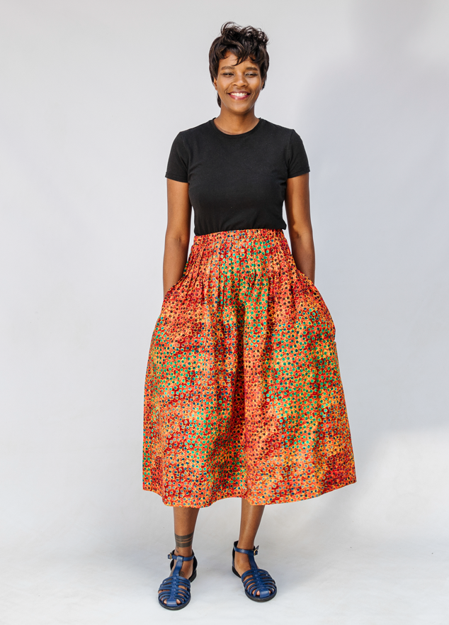 Model wearing multicolored dot print skirt.