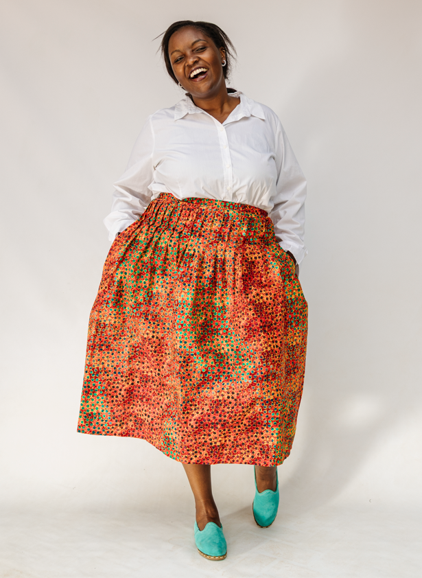 Model wearing multicolored dot print skirt.