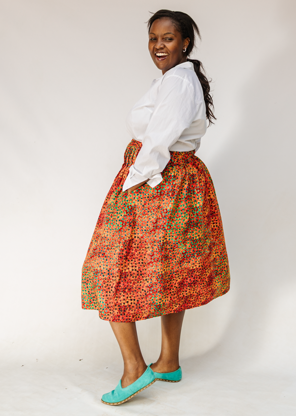 Model wearing multicolored dot print skirt.