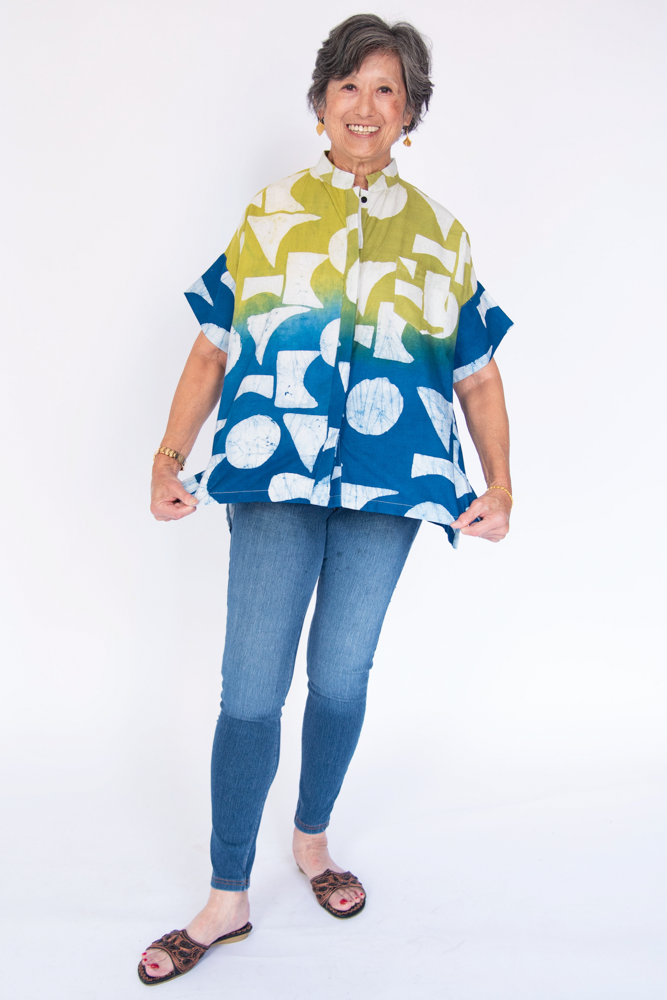 Model wearing yellow, green and blue geometric print batik shirt.