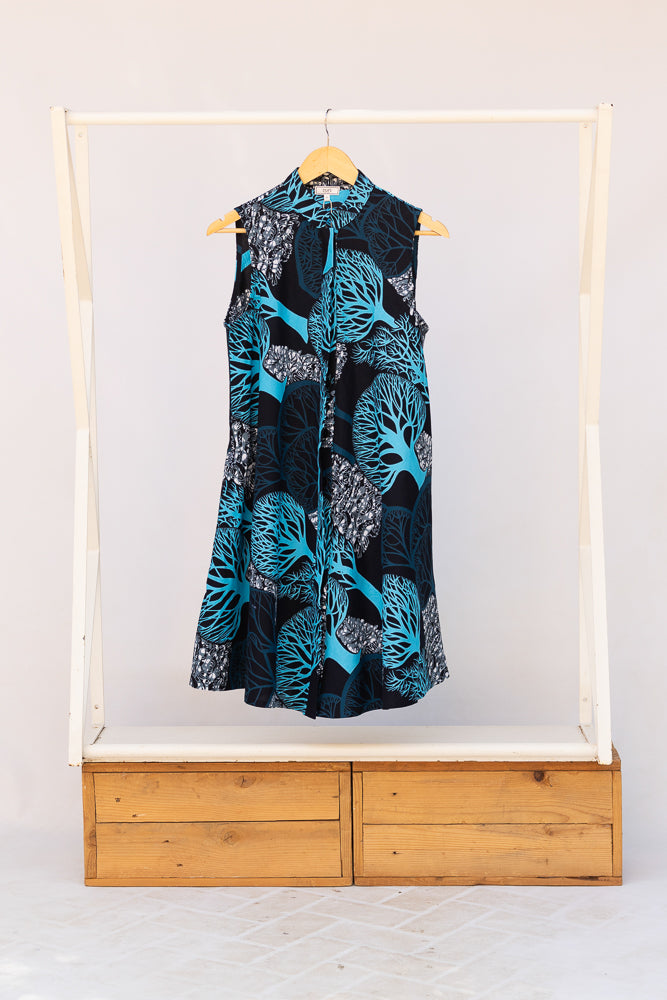 Display of sleeveless dress with blue tree print.