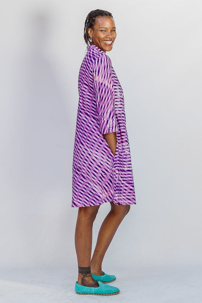 Model wearing purple and pink plaid batik dress.