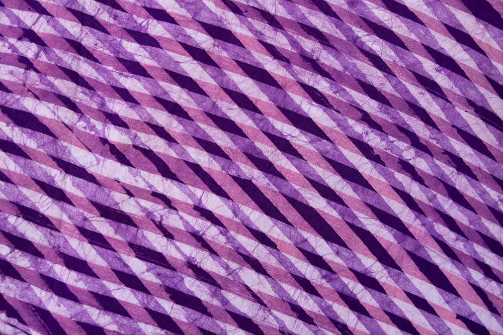 Close up display of purple and pink plaid batik dress, fabric.