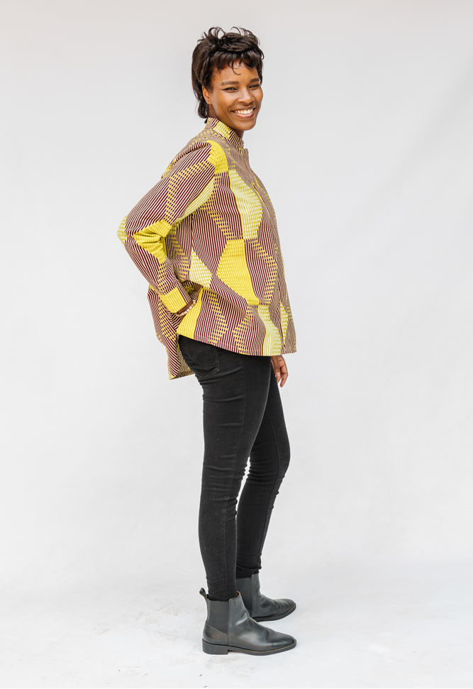 Model wearing yellow, brown and white abstract print shirt.
