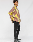 Model wearing yellow, brown and white abstract print shirt.