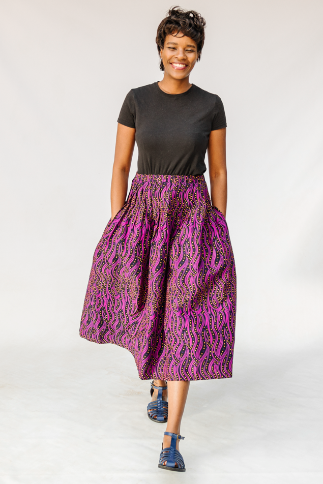 Model wearing fuchsia skirt with small dot design.