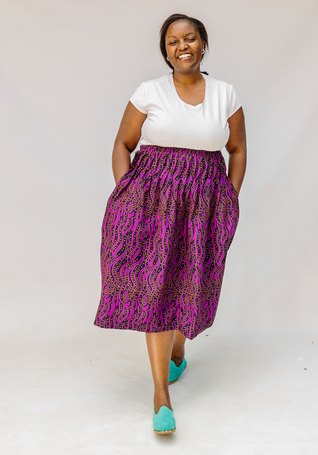 Model wearing fuchsia skirt with small dot design.