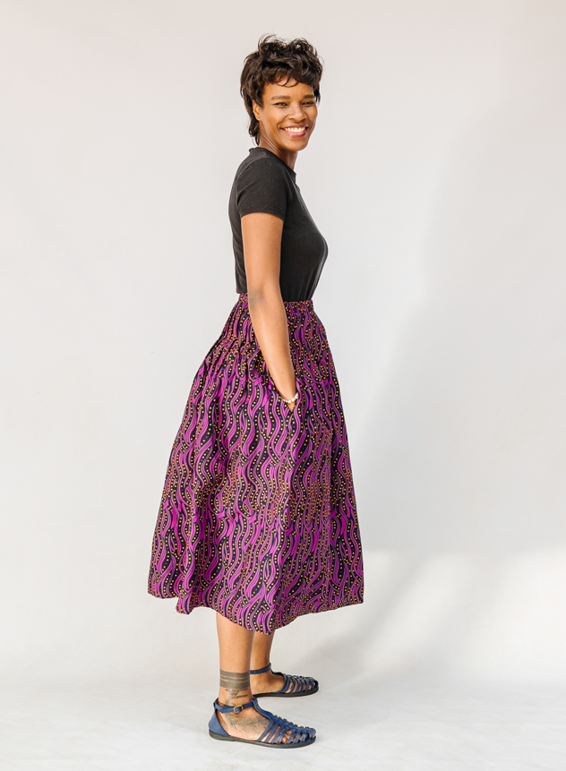 Model wearing fuchsia skirt with small dot design.