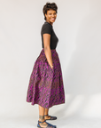 Model wearing fuchsia skirt with small dot design.