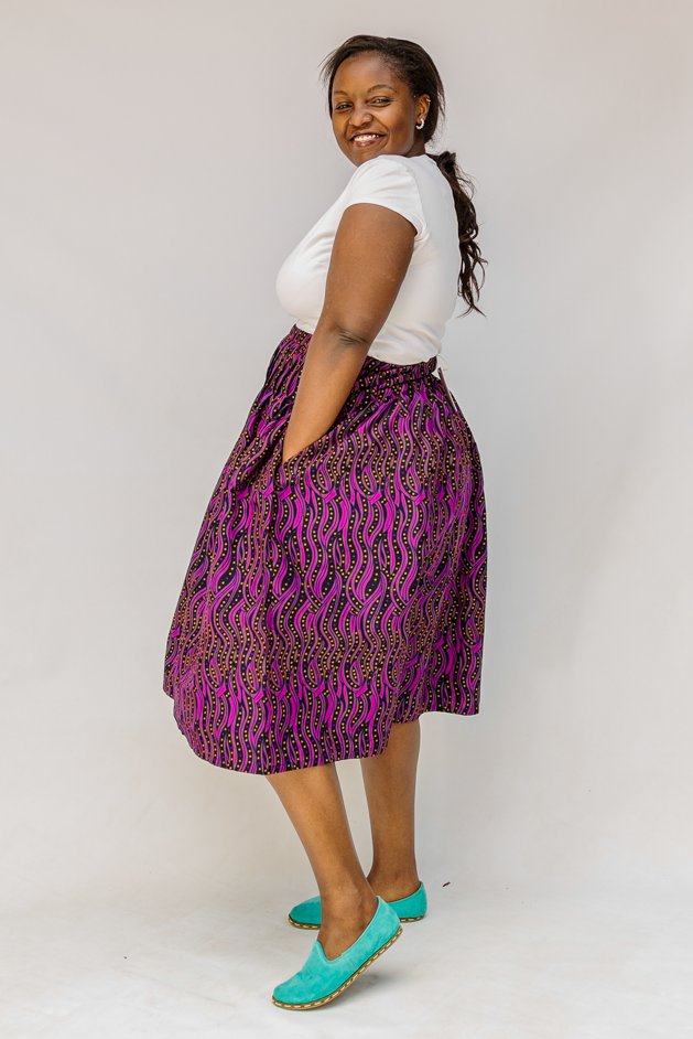 Model wearing fuchsia skirt with small dot design.