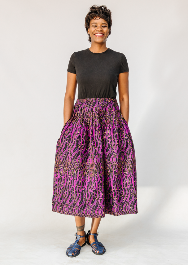 Model wearing fuchsia skirt with small dot design.