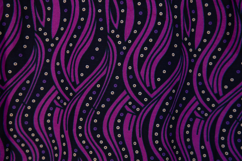 Close up display of purple and black abstract print sleeveless shirt, fabric.