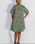 Model wearing blue, yellow, orange and black geometric print dress.