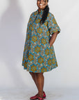 Model wearing blue, yellow, orange and black geometric print dress.