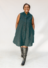 Model wearing sleeveless black dress with teal moon design.