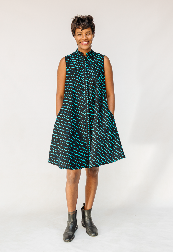 Model wearing sleeveless black dress with teal moon design.