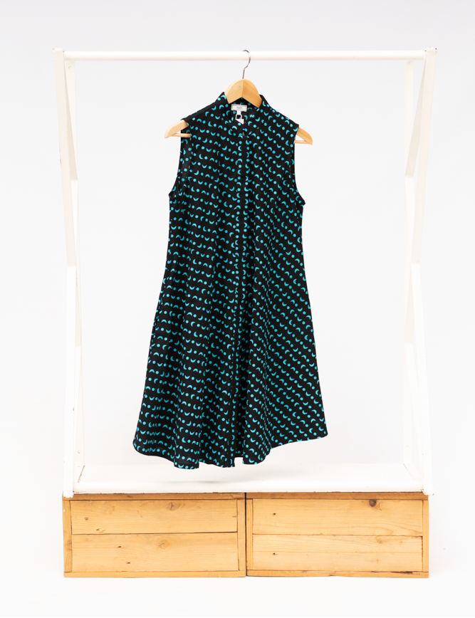 Display of sleeveless black dress with teal moon design.