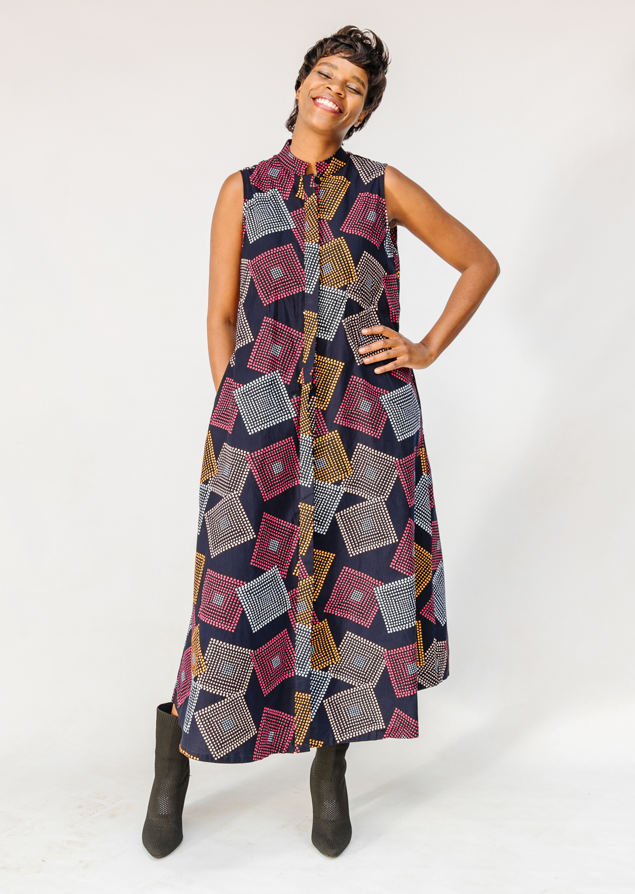 Model wearing pink, orange, white and black geometric print dress.
