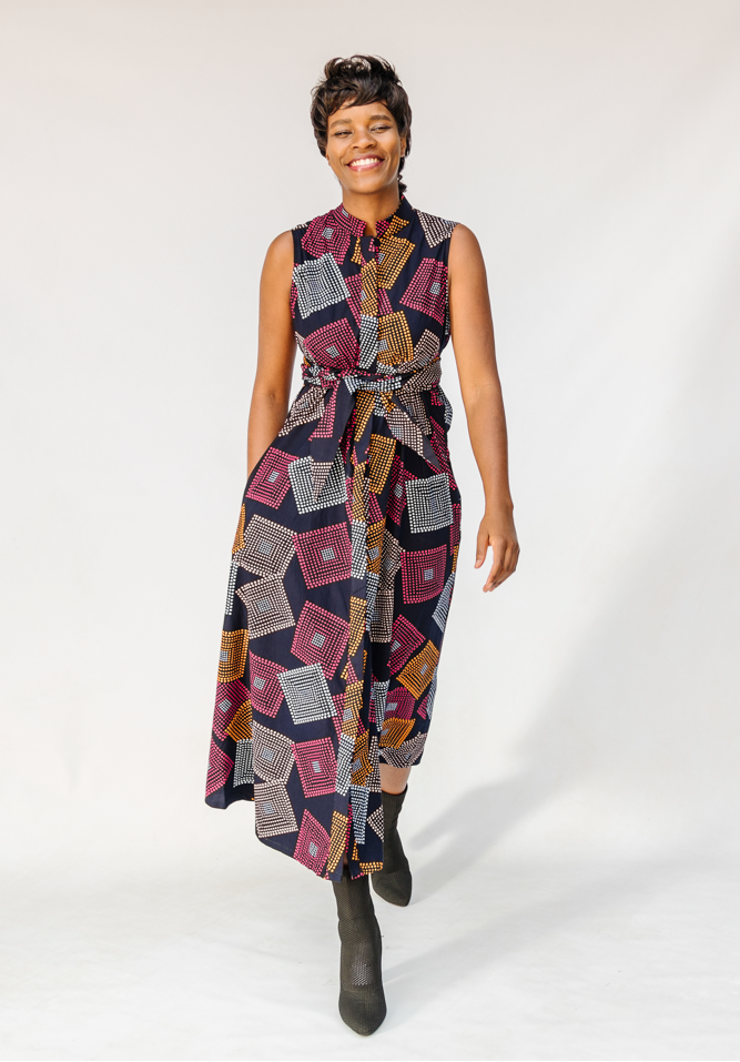 Model wearing pink, orange, white and black geometric print dress.