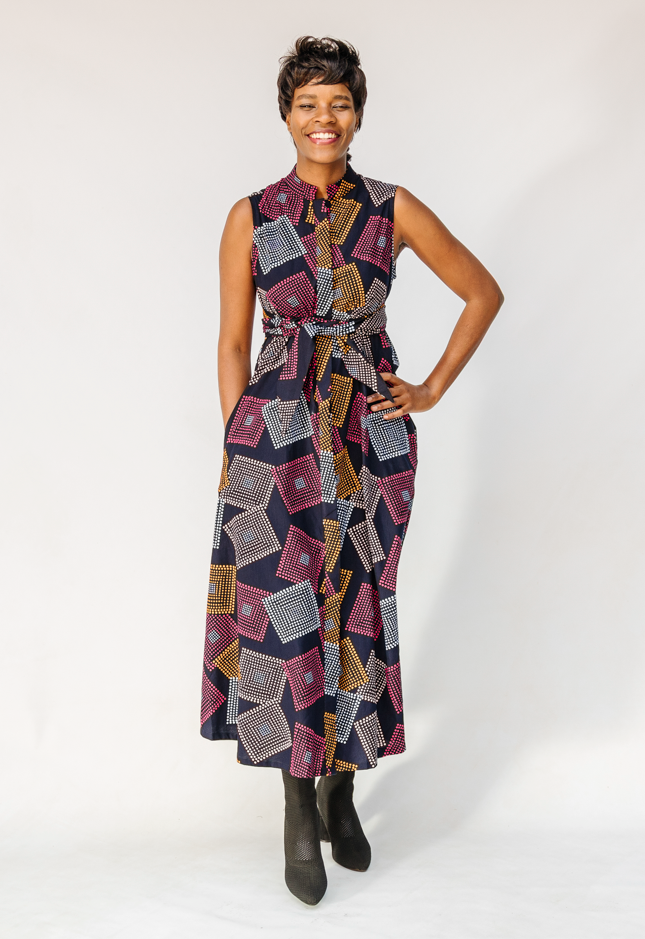 Model wearing pink, orange, white and black geometric print dress.