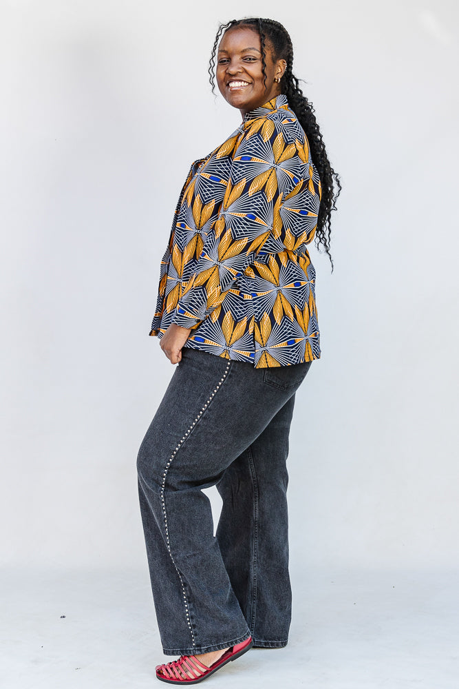 Model wearing blue, white and yellow abstract print shirt.